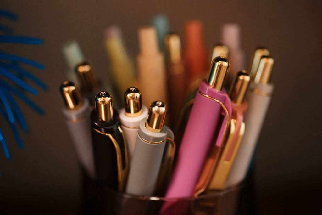 Assorted colorful pens in a cup